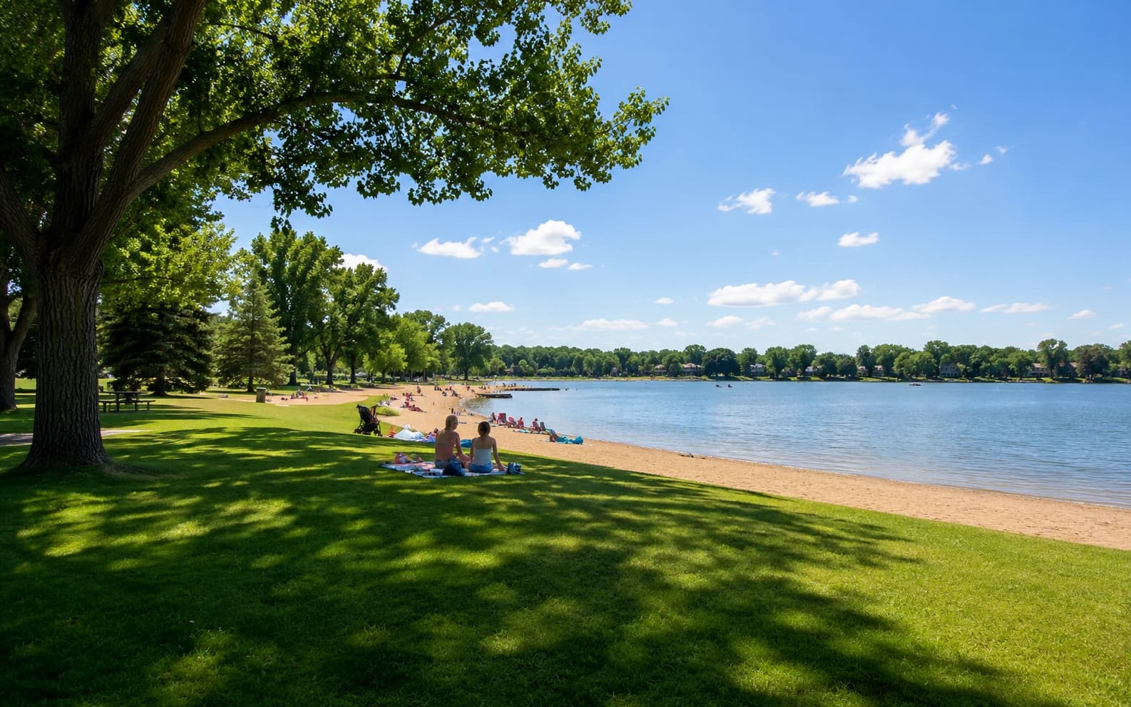 A lake beach area in a Woodbury, Minnesota park with people enjoying the water on a summer day