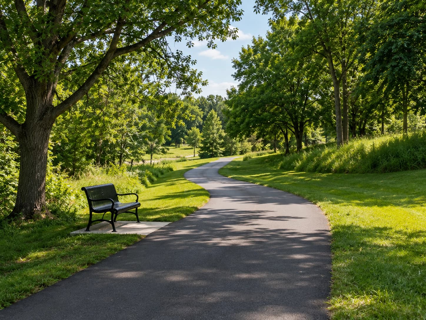 A paved walking and biking trail winding through a Woodbury, Minnesota neighborhood park